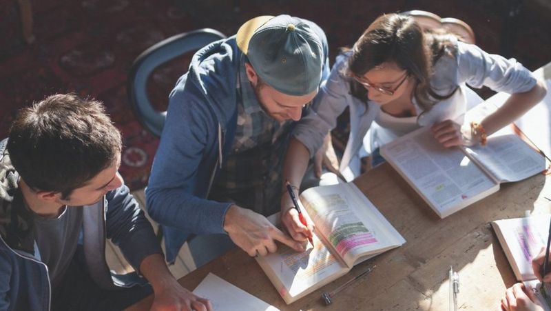 Students studying   with printed text book